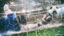 Goalkeeper catches the ball in the stadium during a football game Naklejkomania - zdjecie 1 - miniatura