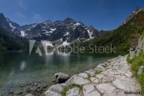 Trail at the mountain lake with rocky summits mirrored in water. Naklejkomania - zdjecie 1 - miniatura