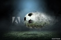 Moving soccer ball around splash drops on the stadium field. Naklejkomania - zdjecie 1 - miniatura