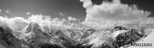 Black and white panorama of snowy sunlit mountains