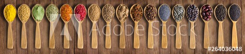 Colorful spices on background wooden table. Seasonings and herbs in wooden spoons for design website headers. - zdjęcie 1