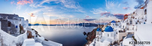 Beautiful panorama view of Santorini island in Greece at sunrise with dramatic sky.