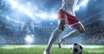 Soccer player kicks the ball on the soccer stadium. He wear unbranded sports clothes. Stadium and crowd made in 3D. Naklejkomania - zdjecie 1 - miniatura