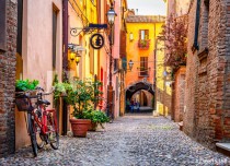 Cozy narrow street in Ferrara, Emilia-Romagna, Italy. Ferrara is capital of the Province of Ferrara Naklejkomania - zdjecie 1 - miniatura