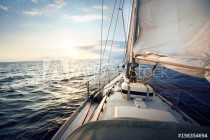 View from the deck to the bow of a sail yacht tilted in a wind on a sunset Naklejkomania - zdjecie 1 - miniatura