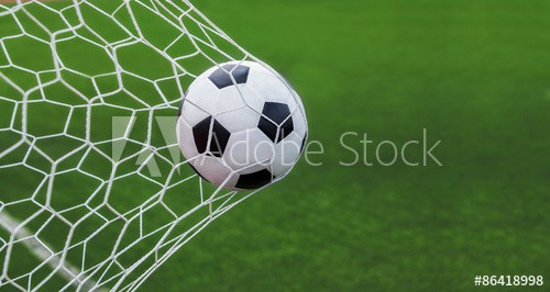 soccer ball in goal with green backgroung