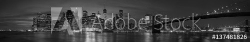 New York city with Brooklyn Bridge, iconic skyline panorama at night in black and white