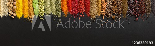 Variety condiments and herbs scattered on background of  black table. Heaps Indian spices on chalkboard with empty space. - zdjęcie 1