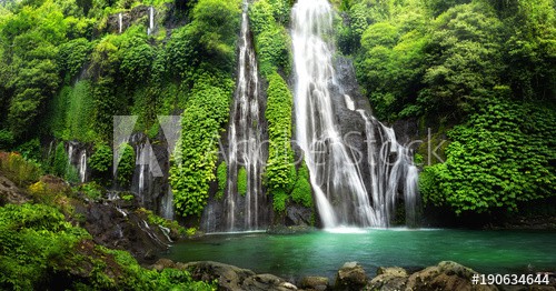 Jungle waterfall cascade in tropical rainforest with rock and turquoise blue pond. Its name Banyumala because its twin waterfall in mountain slope - zdjęcie 1