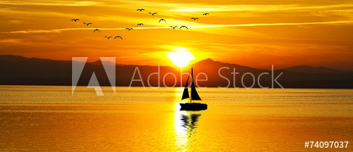 puesta de sol panoramica en el mar con un velero